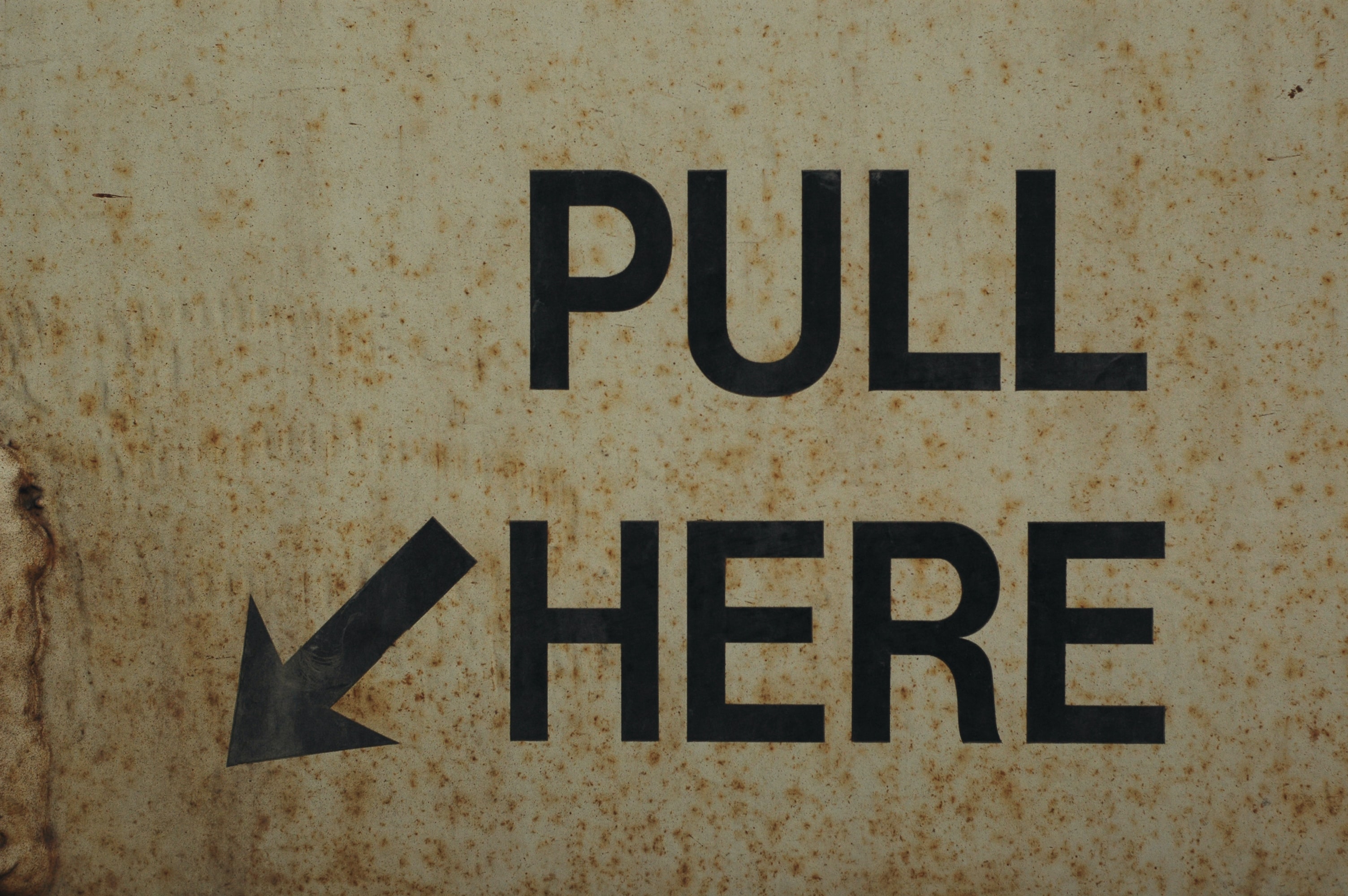 Image with examples of signifiers on a door. A "Pull Here" text and an arrow pointing to a handler.
